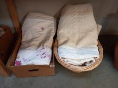 A basket & box of bed spread quilts