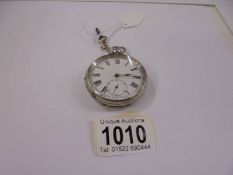 A silver pocket watch with key.