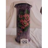 A Longpark Torquay vase with three lips. Brown on the inside, purple outside with flowers.