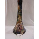 An 11" high Longpark vase with a wide base and narrower neck. Applied flowers and leaves