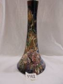 An 11" high Longpark vase with a wide base and narrower neck. Applied flowers and leaves