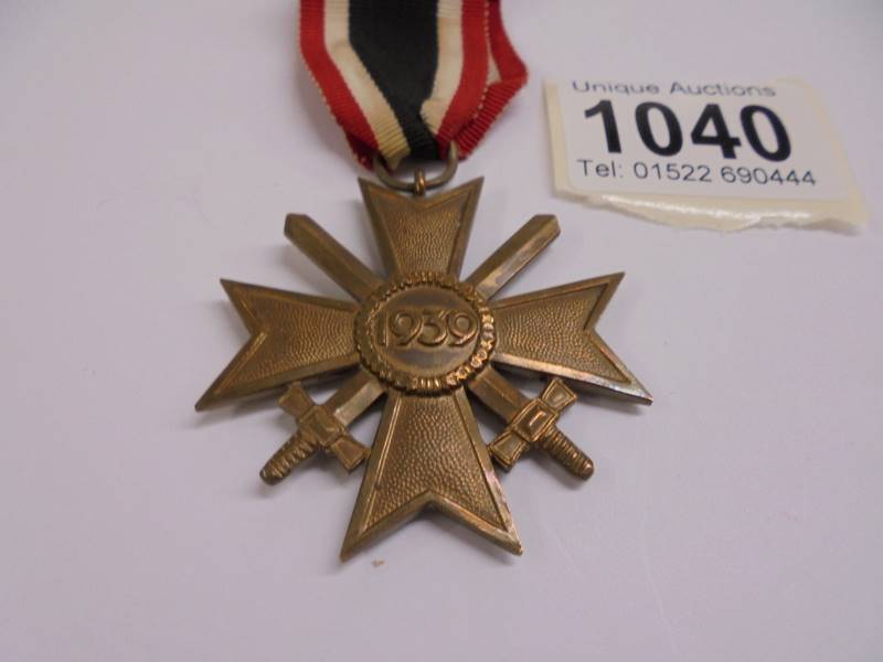 A Geman army war merit cross medal, post-WW2 1957 pattern, crossed swords with ribbon bar. - Image 2 of 3