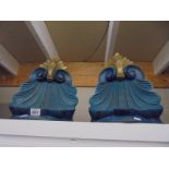 A pair of carved wood wall brackets in blue and gold.