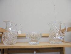 Two cut glass jugs and a cut glass bowl.