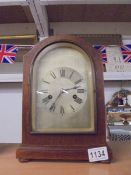 An oak cased clock with silvered dial complete with pendulum and key.