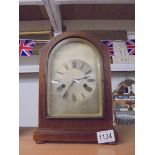 An oak cased clock with silvered dial complete with pendulum and key.