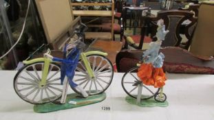 An Italian ceramic male and female figures on bicycle and penny farthing, (man missing right arm