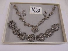 A suite of vintage jewellery comprising necklace, bracelet and earrings in white metal.