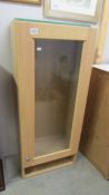 A light wood effect display cabinet. COLLECT ONLY.