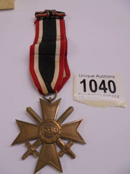 A Geman army war merit cross medal, post-WW2 1957 pattern, crossed swords with ribbon bar.
