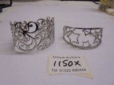 Two decorative white metal bangles.