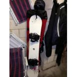 A snowboard with bag and helmet