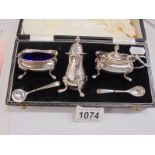 A cased silver condiment set with blue glass liners, total silver weight 140 grams.