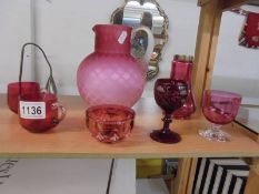 A pink satin glass jug and six items of cranberry glass.