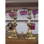 A pair of Victorian brass candlesticks with pushers.