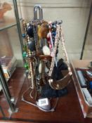 A quantity of costume jewellery necklaces on stand