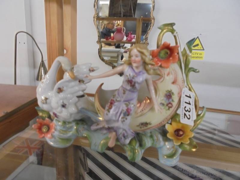 A porcelain carriage with swan and lady figure, (damage to thumb on right hand).