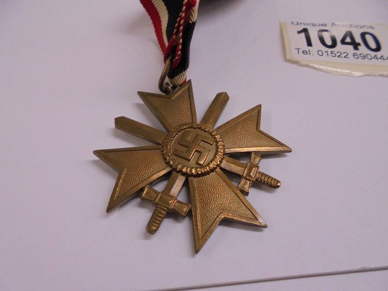 A Geman army war merit cross medal, post-WW2 1957 pattern, crossed swords with ribbon bar. - Image 3 of 3