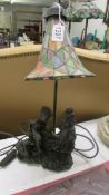 A table lamp featuring a boy, girl and duck with a Tiffany style shade.