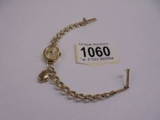 A 9ct gold watch on a 9ct gold bracelet with attached opening locker, 11 grams.