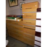 A lightwood effect 8 drawer bedroom chest of drawers and 2 x 3 bedsides