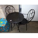 A wrought iron patio garden table and 2 chairs