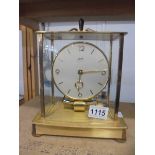 A Kundo electro magnetic clock in glass and brass case, 6 jewels, in working order.