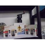 A coffee grinder, a tea maker and boxed Bodum coffee mugs.