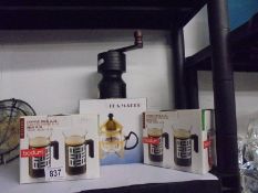 A coffee grinder, a tea maker and boxed Bodum coffee mugs.