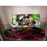 A multi coloured designer handbag decorated with a snake and with feather strap.