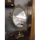 An oval brass framed mirror.