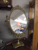An oval brass framed mirror.