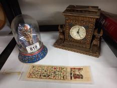 An Egyptian style clock, Tut-Ankh-amun death mask under dome and book mark.