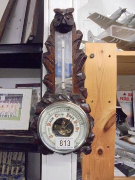 A vintage oak Black Forest barometer depicting an owl with glass eyes.