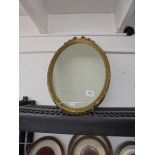 An oval gilt framed mirror. COLLECT ONLY.