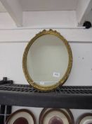 An oval gilt framed mirror. COLLECT ONLY.