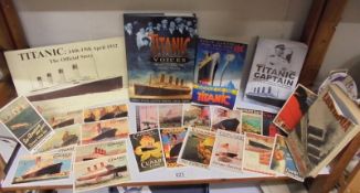 A collection of Titanic related books and Cunard Line postcards.