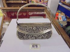 A decorative white metal evening bag.