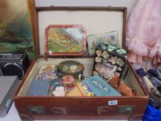 A vintage suitcase and a quantity of vintage tins.