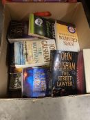 A box of John Grisham paperbacks