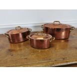 Set of three copper lidded sauce pans.