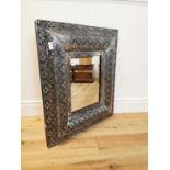 Embossed metal framed wall mirror.