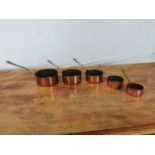 Set of five copper and brass sauce saucepans.