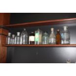 Ten brown glass chemist bottles with labels.