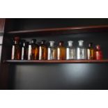 Ten brown glass chemist bottles with labels.