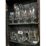 Two shelves of pint and half pint Guinness Glasses