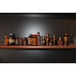 Fourteen brown glass chemist bottles.