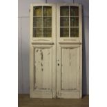 Pair of painted wooden doors with stain glass inserts.