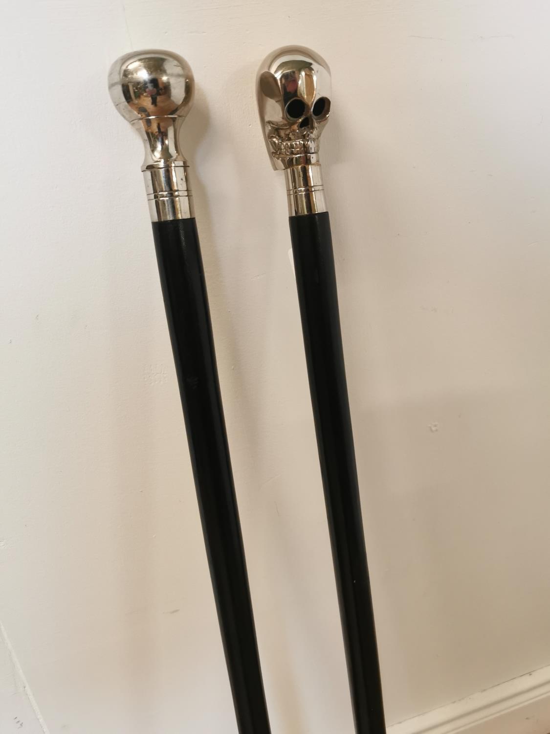 Two ebony and polished steel walking sticks.