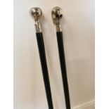Two ebony and polished steel walking sticks.